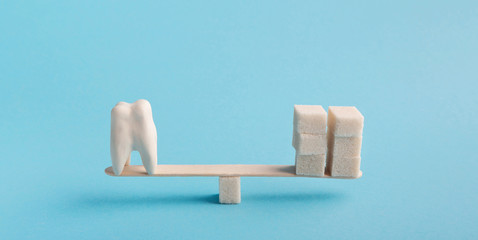 Healthy tooth and sugar balancing on seesaw swing