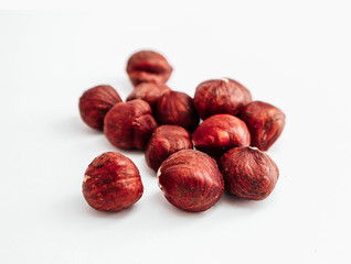 A pile of brown raw hazelnuts, isolated on white background.