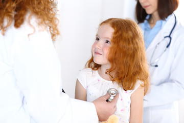 Obraz premium Doctor examining a little girl with stethoscope.Medicine and healthcare concept