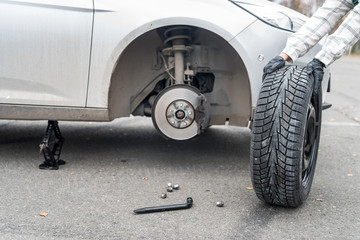Worker hands with spare wheel, close up