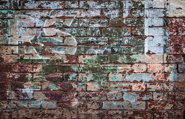 Close-up detail on old faded sign on brick wall of abandoned building
