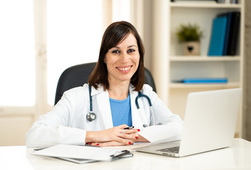 Female doctor working on medical expertise and searching information on laptop at hospital office