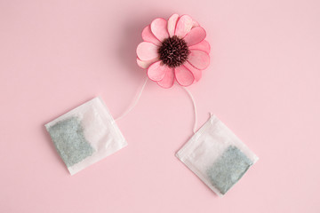 Tea time abstract with pink flower and tea bags.