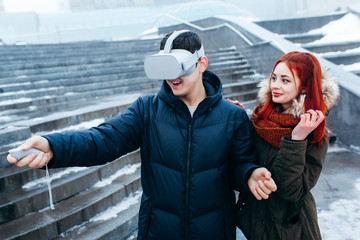 Obraz premium Young couple experiencing virtual reality (VR) on the street
