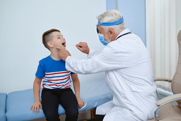 Obraz premium Doctor in uniform in mask treating young patient.