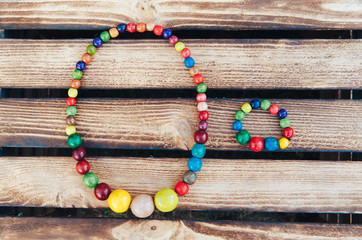 Handmade Colored  Jewelry. Colored beads and wood bracelet. Wooden background