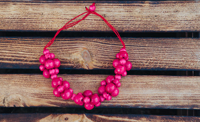 Pink beads handmade. Wooden background. Handmade wood. Top view