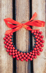 Red and black beads handmade. Wooden background. Top view. Ukrainian style