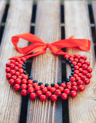 Red and black beads handmade. Wooden background. Ukrainian style