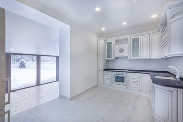 New white kitchen with tiled floor and doorway to the veranda