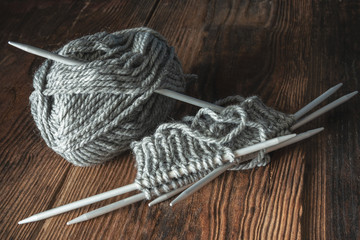 Strickzeug, graue Wolle mit fünf Stricknadeln, Socken stricken