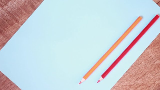 Five multicolored pencils over blue paper