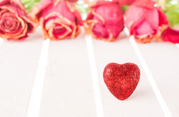 Red heart and rose on white wood background.