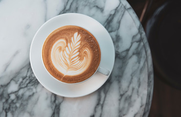 latte or Cappuccino with frothy foam, coffee cup top view on table in cafe.