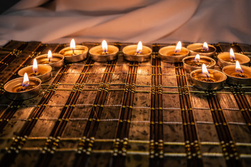 Sweets, milk candies and dark chocolate broken, on the background of lights, candles. Warm, soft and pleasant shade. Dessert is gentle and natural in a romantic home environment.