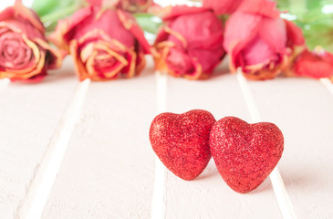 Two red hearts and rose on white wood background.