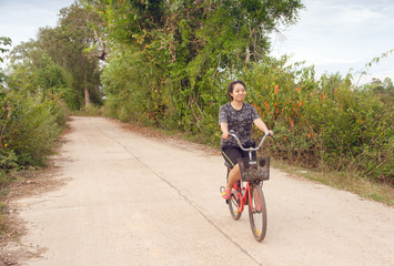 Naklejka premium Woman riding bicycle relax in a country road.
