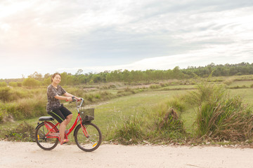 Obraz premium Woman riding bicycle relax in a country road.