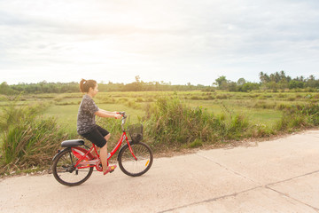 Obraz premium Woman riding bicycle relax in a country road.