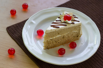 vanilla cake is in dish.Decorate with jelly cherry and cream.It is sweet.