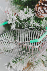 small Christmas tree with shopping basket hanging among its branches