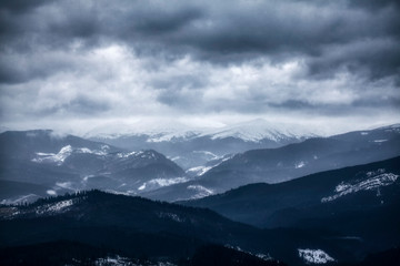 low clouds over black mountains