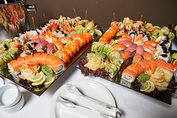 Decorated catering banquet table with different sushi rolls and nigiri sushi plate assortment on a party