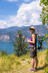 Naklejka premium Hiking in Italy: Girl with straw hat is enjoying the view, summertime and beautiful landscape