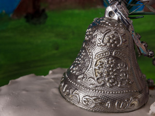 Silver Christmas bell closeup with blurred background,