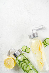 Organic summer cold refreshing drink, detox infused water, with lemon fruit and cucumber vegetables. Vegan lifestyle, weight loss and fitness. On a light wooden background, copy space