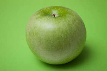 Closeup of green apple on green background