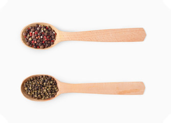 Wooden spoons with aromatic culinary condiments on white