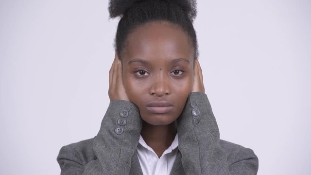 Face of young African businesswoman covering ears as three wise monkeys concept