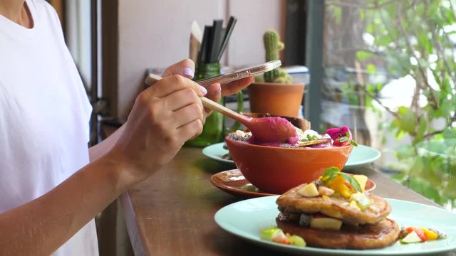 Woman Food Blogger Using Smartphone Taking Photo Of Food In Cafe