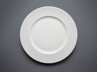 empty white plate from above on grey background
