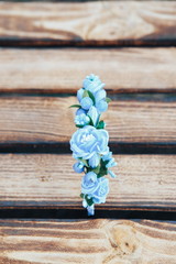 Handmade hoop blue flowers. Blue hair band on wooden background. Top view