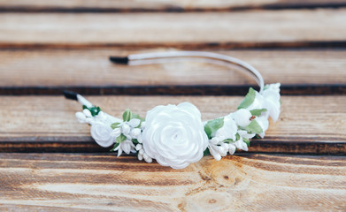 Handmade hoop white flowers. White hair band on wooden background