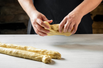 Male baker making traditional challah jewish bread. Cooking steps process food concept.