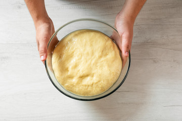 Man holding bowl with dough for traditional bread.