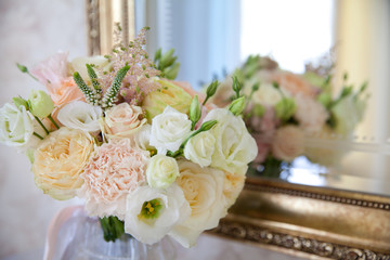 Beautiful bouquet of flowers near the mirror.