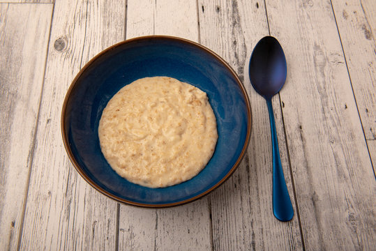 Bowl Of Plain Porridge Oats On A Wooden Table 