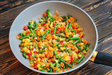 Vegetables fried in a ceramic pan with a small amount of olive oil.