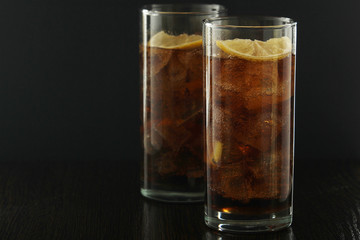 Glasses with cuba libre cocktail or cola with ice or cold tea with lemon