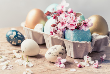 Easter eggs and spring flowers on rustic wooden background.Easter holiday card copy space.
