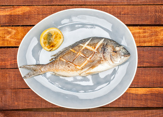 Baked fish on a plate with lemon