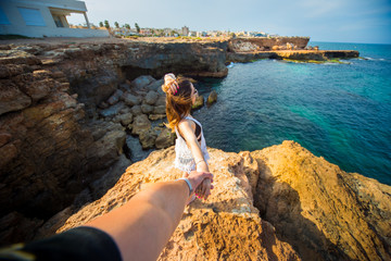 Follow me photo model Stan on edge of rock with sea view on font 