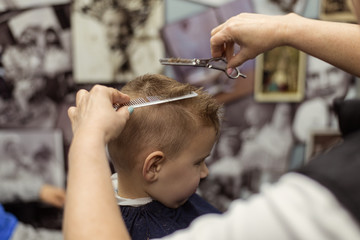 Little boy at the hairdresser. Child is scared of haircuts.