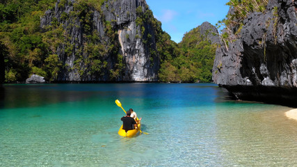 people on a canoe in lagoons with cliffs, philippines - 242301192