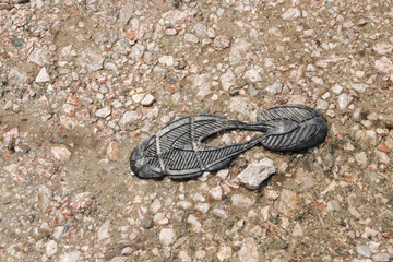 Torn off shoe sole on a hiking trail, torn hiking shoe on the hiking trail