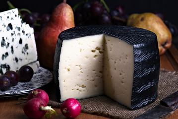 Spanish sheep cheese and Roquefort cheese with pomegranates, pears and bodegon grapes with classic light on wood